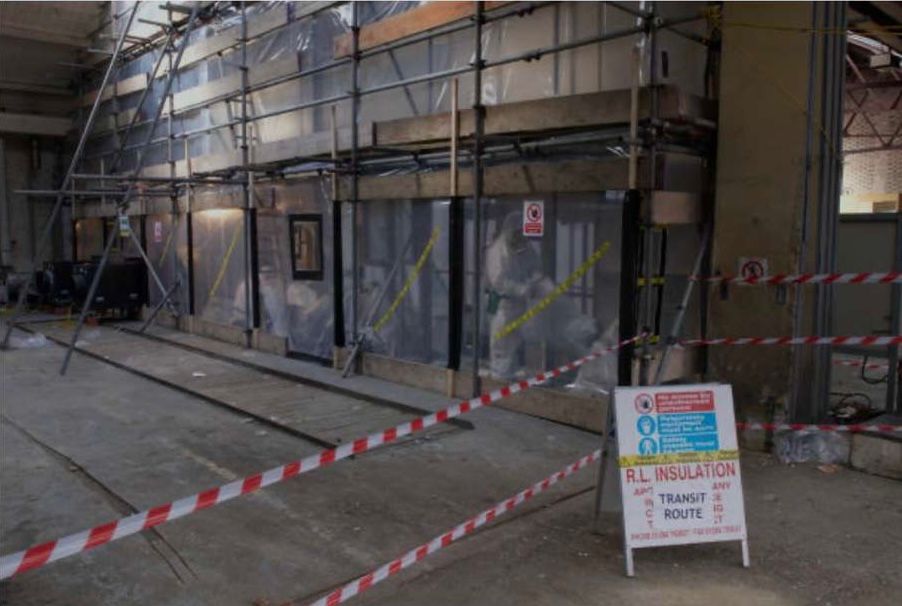 Licensed asbestos removal site with roof removed and internal structure exposed